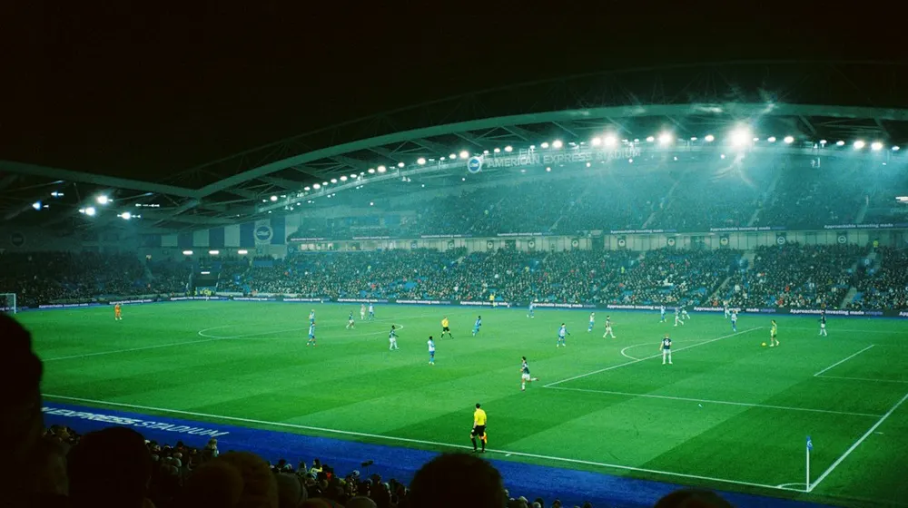 Floodlit cricket stadium during a live match